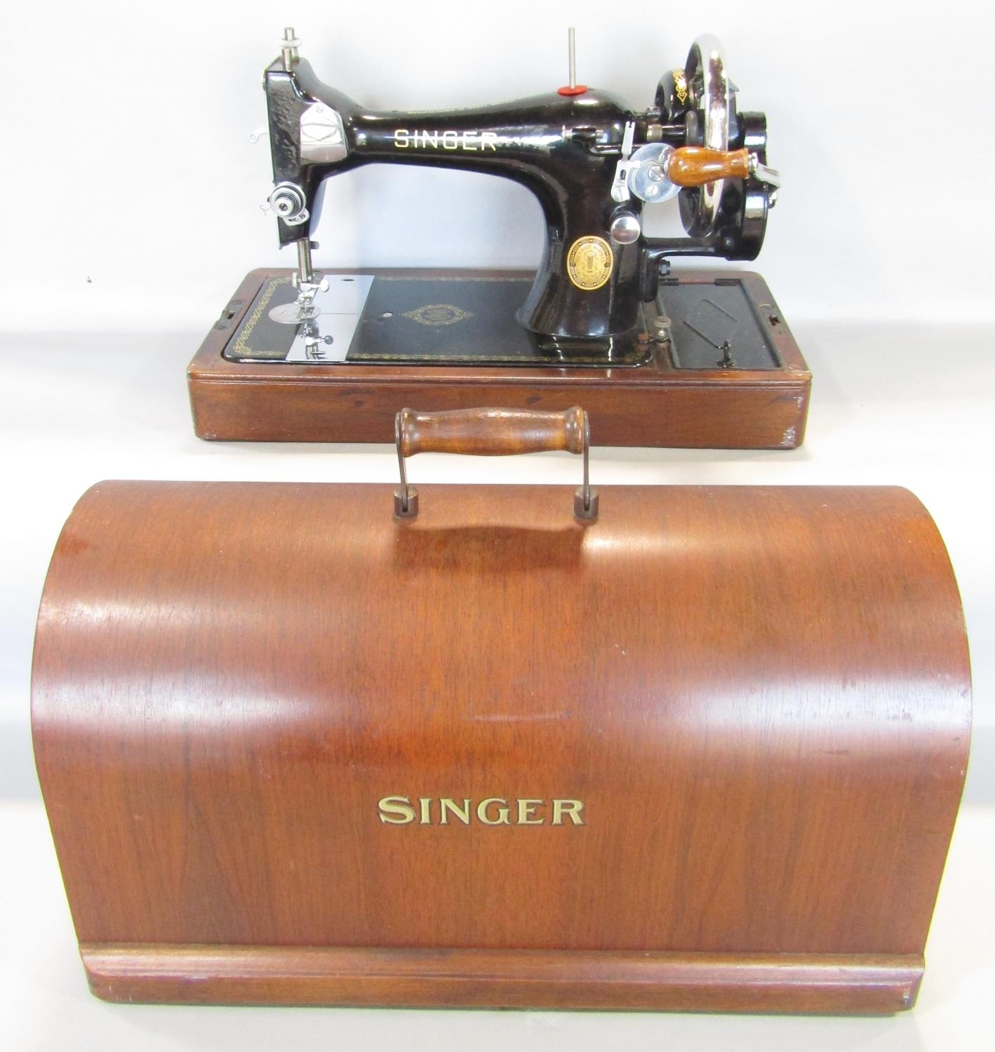 A vintage Singer sewing machine in a domed travelling case