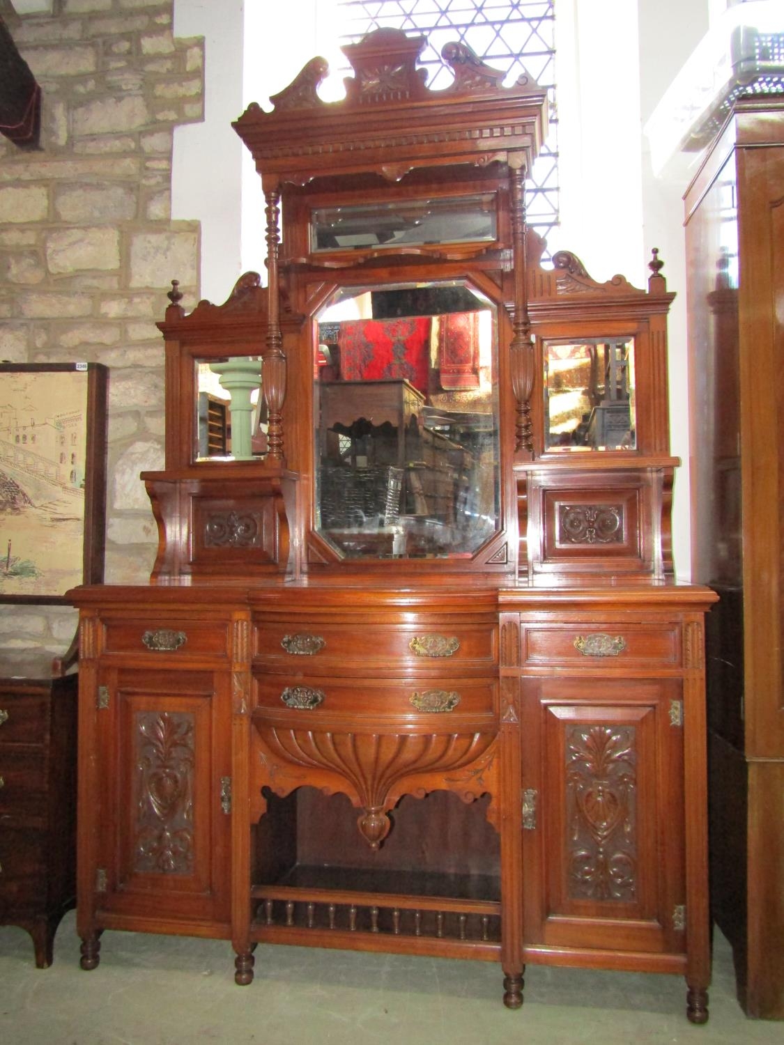 A late Victorian/Edwardian walnut mirror back sideboard the base enclosed by an arrangement of