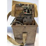 A WWII Morse Code signalling lamp held in a metal twin hinged box with canvas cover and strap.
