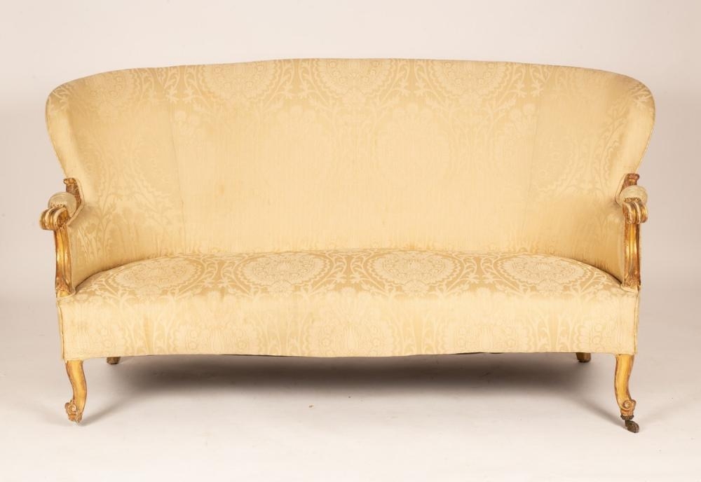 An upholstered settee of Louis XV style with shaped back and giltwood scroll arms on cabriole