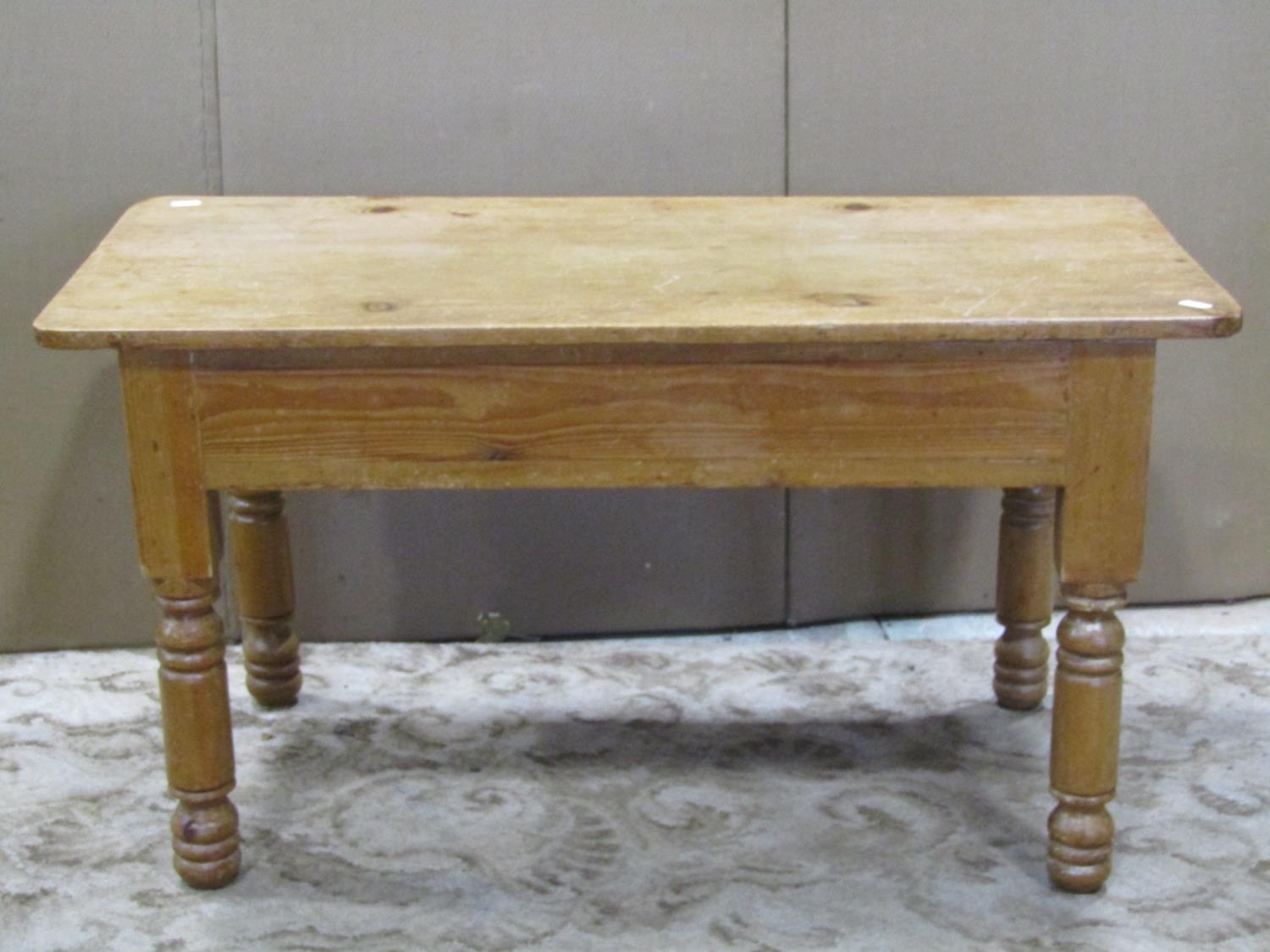 A stripped pine occasional table of rectangular form raised on turned supports, 91 cm long x 44 cm