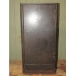 A vintage industrial steel floorstanding side cabinet enclosed by a single door flanked by rounded