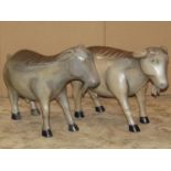 A pair of decorative carved hardwood studies of standing goats, with painted finish, 40cm high x