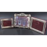 Two matching silver plated photo frames with shells to the corners, and a third silver plated