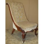 A Victorian nursing chair with upholstered seat and button scrolled back within a walnut show wood