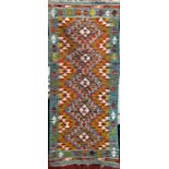 A Chobi Kilim Runner with a tight interlocking multicoloured diamond pattern, 142cm x 59cm approx.