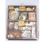 A tobacconist cigarette display cabinet with a selection of fossils, shells and rock samples.