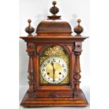 19th century German walnut mantle clock enclosing an arched brass dial with silvered chapter ring,