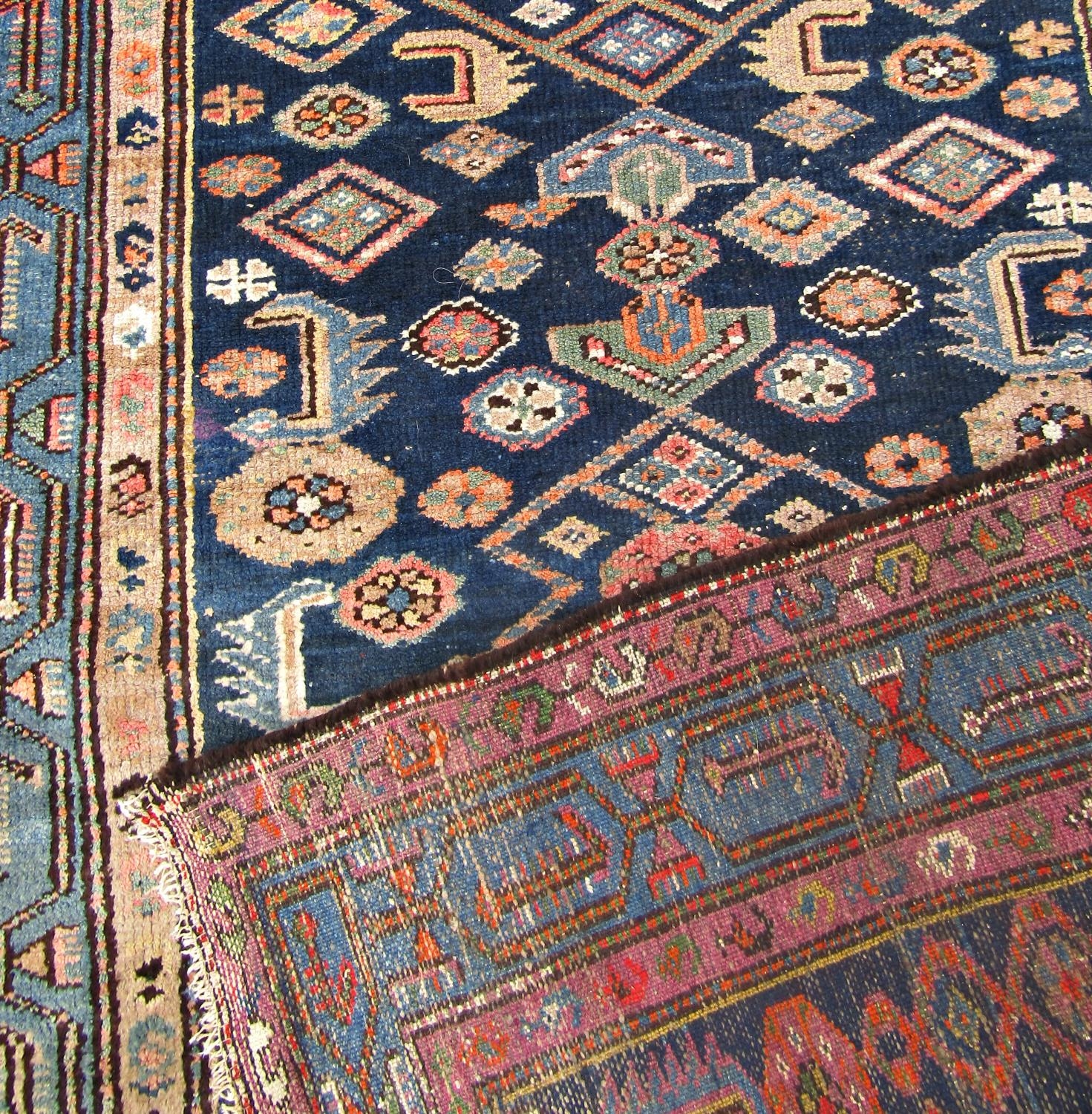 An old Malayer carpet with a repeating geometric pattern on a blue ground - Image 2 of 2