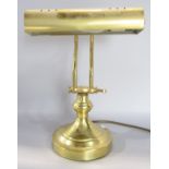 A brass adjustable desk lamp.