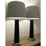 A pair of contemporary table lamps by OKA with cylindrical tapered black lacquered columns on square