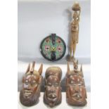 A beaded Zulu carved mask, three other hardwood carved masks from Africa and a carved wooden
