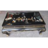 A Chinese lacquered occasional table in a black colourway, the top decorated in relief with