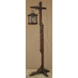 An Old English style oak adjustable standard lamp with square lantern enclosing frosted glass panels