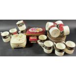 Eleven tudor Rose pattern coffee cans and saucers, two Limoges porcelain boxes and three leaf plates