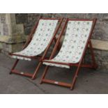 A pair of contemporary folding hardwood deck chairs