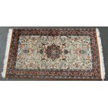 A Persian Tabriz carpet with an all over floral pattern and a central floral medallion. 160cm x 90cm
