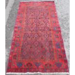A Turkish wool carpet with diamond eye pattern on a predominantly red ground. 210cm x 115cm approx.