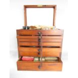 An Edwardian mahogany dentist’s instrument drawer with a hinged top section containing glass jars,