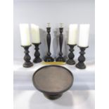 A timber lazy Susan, four carved timber candlesticks, a further pair, all with ebonised finish