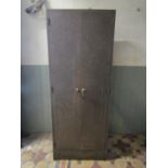 A vintage industrial steel floorstanding side cabinet enclosed by a pair of full length