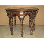A Victorian carved oak occasional table of octagonal form with foliate detail raised on turned