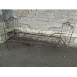 An antique folding steel bed with decorative scrollwork detail
