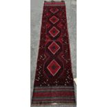 A Meshwani Runner with a predominantly red and blue diamond pattern 258cm x 57cm approx.