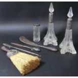A pair of Eiffel Tower inspired cut glass scent bottles with silver collars, a silver capped