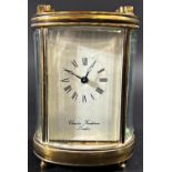A small brass carriage clock, the oval case enclosing an eight day movement, Charles Frodsham of