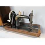 A vintage table top sewing machine, make unknown, with a walnut and mahogany inlaid case.
