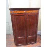 A Georgian mahogany hanging corner cupboard enclosed by a pair of panelled doors enclosing four