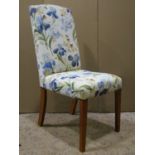 Set of eight dining chairs with floral patterned upholstered seats and backs, raised on simple