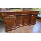 A Victorian mahogany inverted breakfront four door sideboard with applied and carved detail, with
