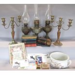 A miscellaneous collection of items including a pair worn candelabra, three brass oil lamps, a