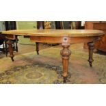 A Victorian oak extending dining table with two additional leaves, with D ends, raised on four