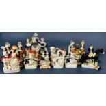 A large collection of Staffordshire flatback figures to include a pair of spaniels, watch stands