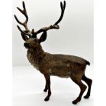 A spelter figure of a stag with antlers, naturalistically painted together with a small cold cast