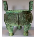 A large bronze Chinese incense burner, with two lop handles raised on three squat supports , (as