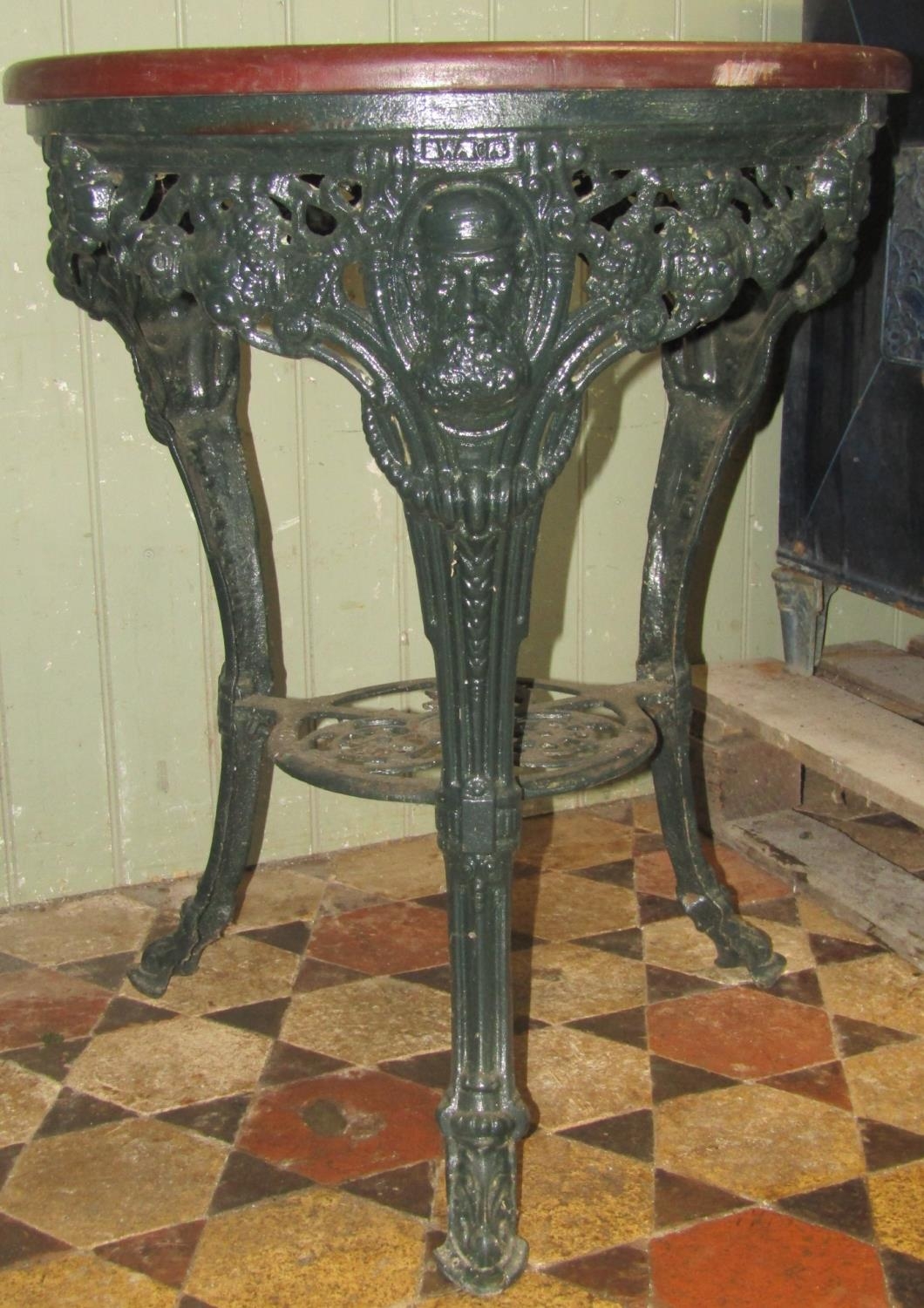 A good quality refurbished cast iron WG Grace mask pub table, with decorative pierced fruiting vine,