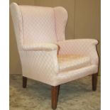Georgian style wing armchair with light pink ground, repeating lattice patterned upholstery, loose