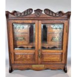 An Edwardian oak smoker’s cabinet with a fitted interior of drawers and pipe rack, 41cm wide.