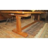 An oak refectory table, the heavy plank top raised on a simple stretcher base united by a central