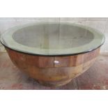 An unusual hardwood centre table in the form of a hollowed bowl, with plate glass top, 92cm diameter