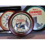 Guinness Memorabilia, two wall clocks and a pair of tin drinks trays.