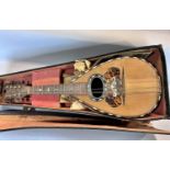 A Pietro Ruffini of Brescia mandolin and case both in need of repair.