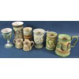 A collection of pottery mugs and vases with hand painted detail