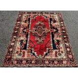 North West Persian Lillian good condition rug, with a stylised floral medallion on a red ground