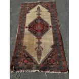 A faded old Kazak carpet an elongated lozenge central medallion, 195cm x 96cm approx and a small