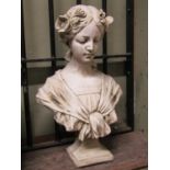 A cast composition stone (to simulated marble) bust of a maiden with flowers in her hair, 47cm high